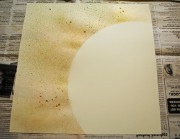 Buckling of paper: The colored (outer) portion was sprayed with ink, causing expansion of the moist paper, which was constrained by the untreated and undeformed circular white region.